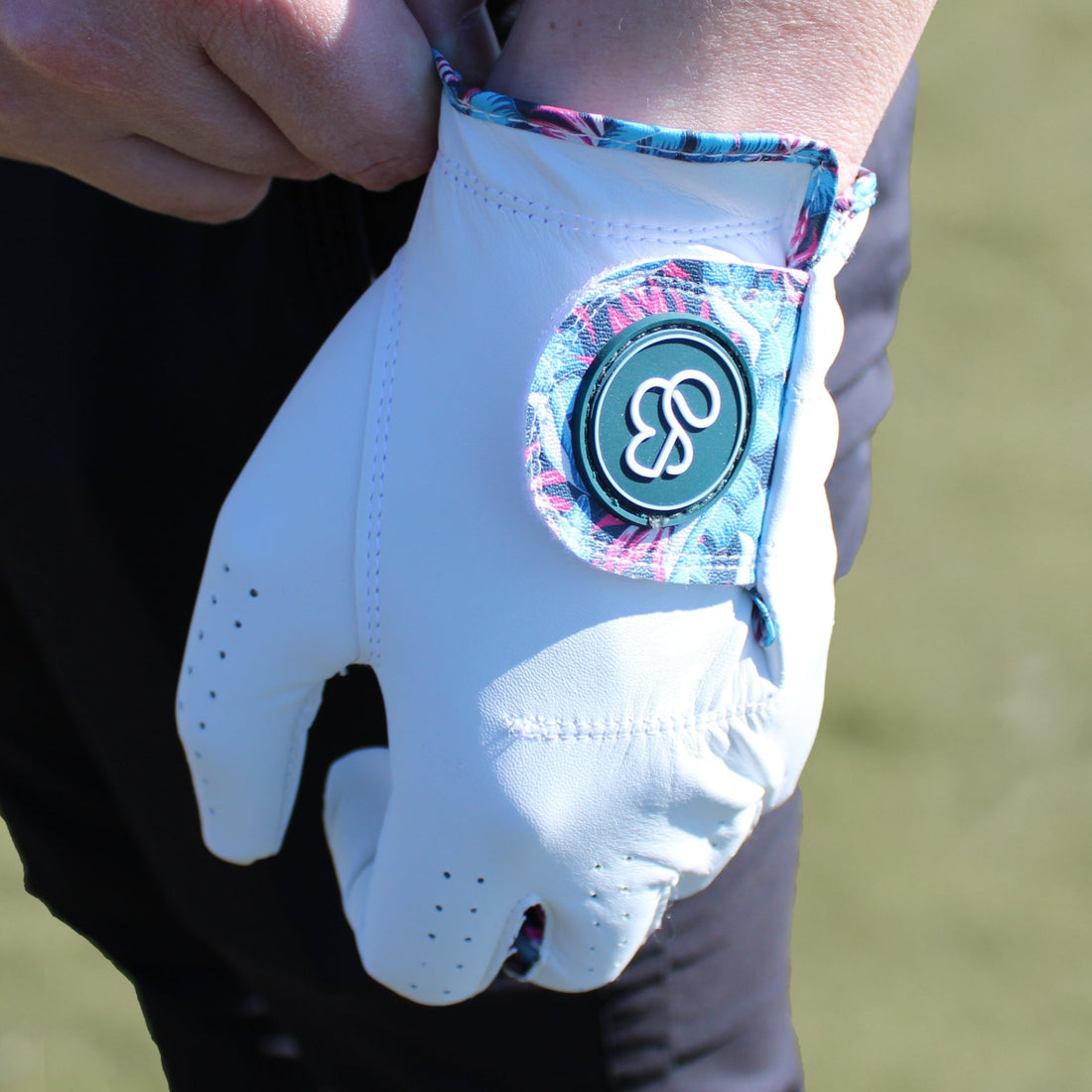 Close up of a premium golf glove being put on to wrist